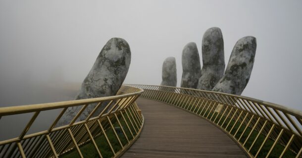 ponte sustentada por mãos gigantes