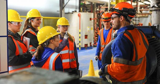 Confira quais serão as Engenharias em alta no mercado de trabalho em 2020 Grupo de pessoas conversando com equipamentos de EPI