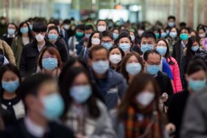 população chinesa usando máscara descartável no rosto para evitar coronavírus