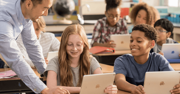 crianças em sala de aula usando iPad na educação com auxílio do professor