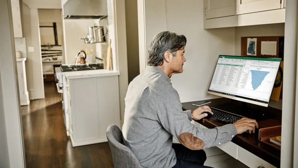homem trabalhando em casa em uma mesa com computador
