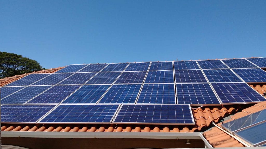 Fotografia de um sistema solar fotovoltaico instalado sob o telhado de uma residência