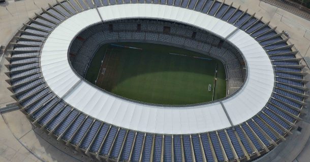 Vista superior do estádio Mineirão. Na imagem é possível enxergar o gramado verde do campo no centro e também os módulos fotovoltaicos na cobertura.