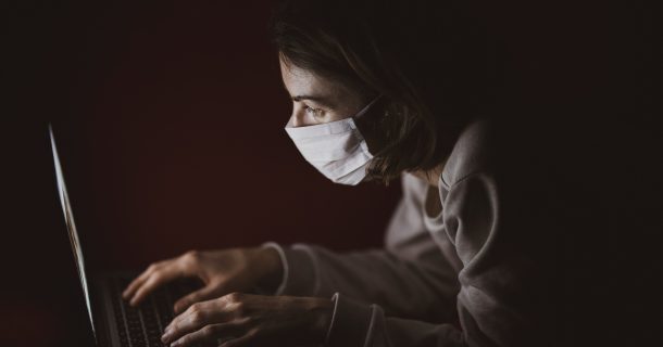 mulher de máscara usando computador, imagem com fundo preto
