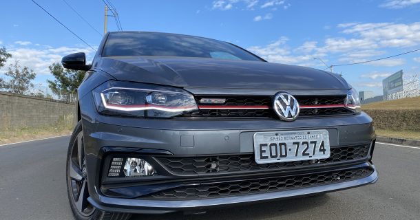 Vista frotal de um carro cinza no meio de uma estrada