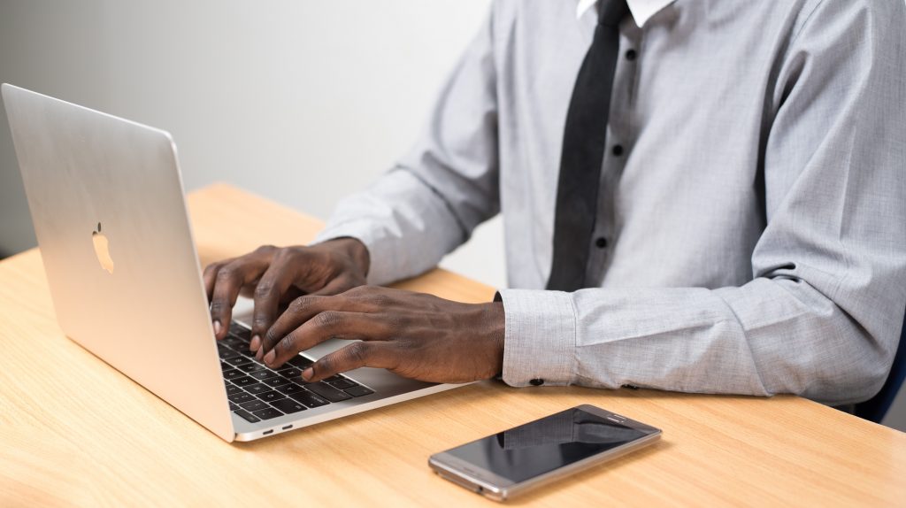 homem negro de terno usando computador em casa para home office