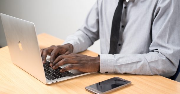 homem negro de terno usando computador em casa para home office