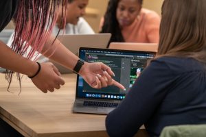 mulheres conversando em frente a computador ilustrando Apple Entrepreneur Camp para mulheres