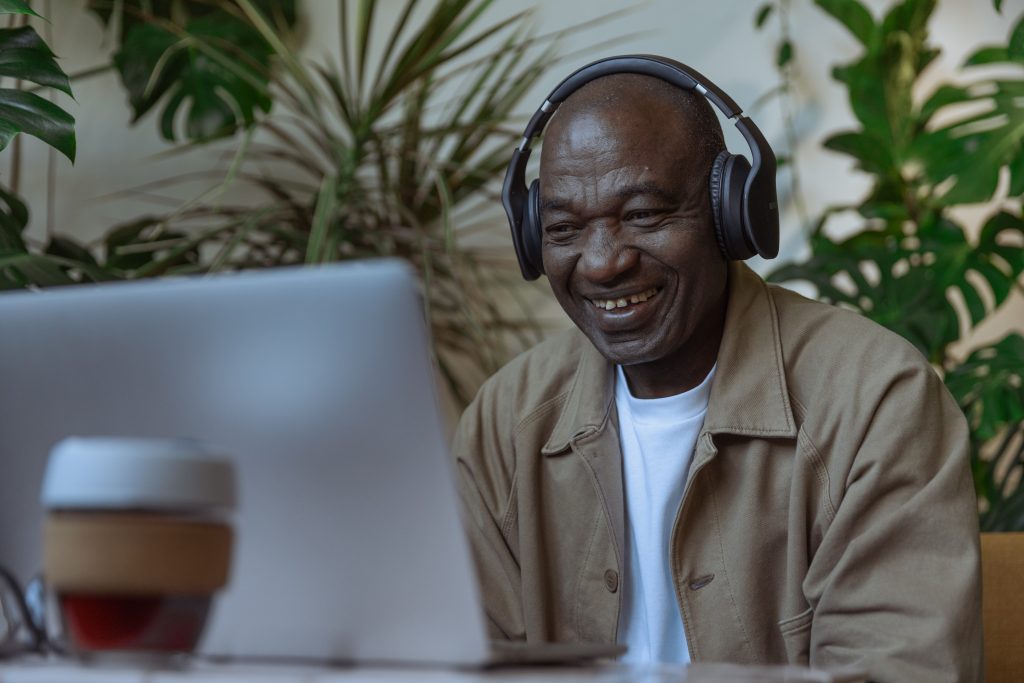 Homem usando fone de ouvido enquanto sorri